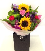Hand tied bouquet of roses, sunflowers and chrysanthemum in vivid tones. 